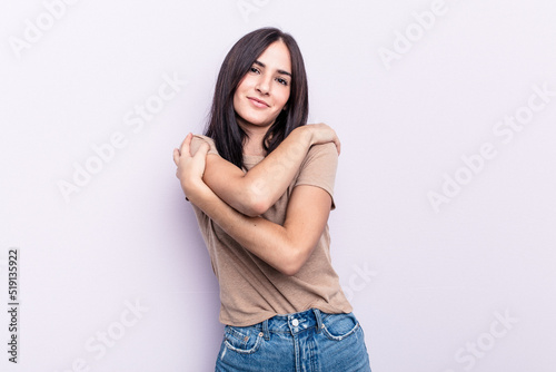 Young caucasian woman isolated on pink background hugs, smiling carefree and happy. © Asier