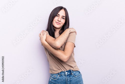 Young caucasian woman isolated on pink background hugs, smiling carefree and happy.