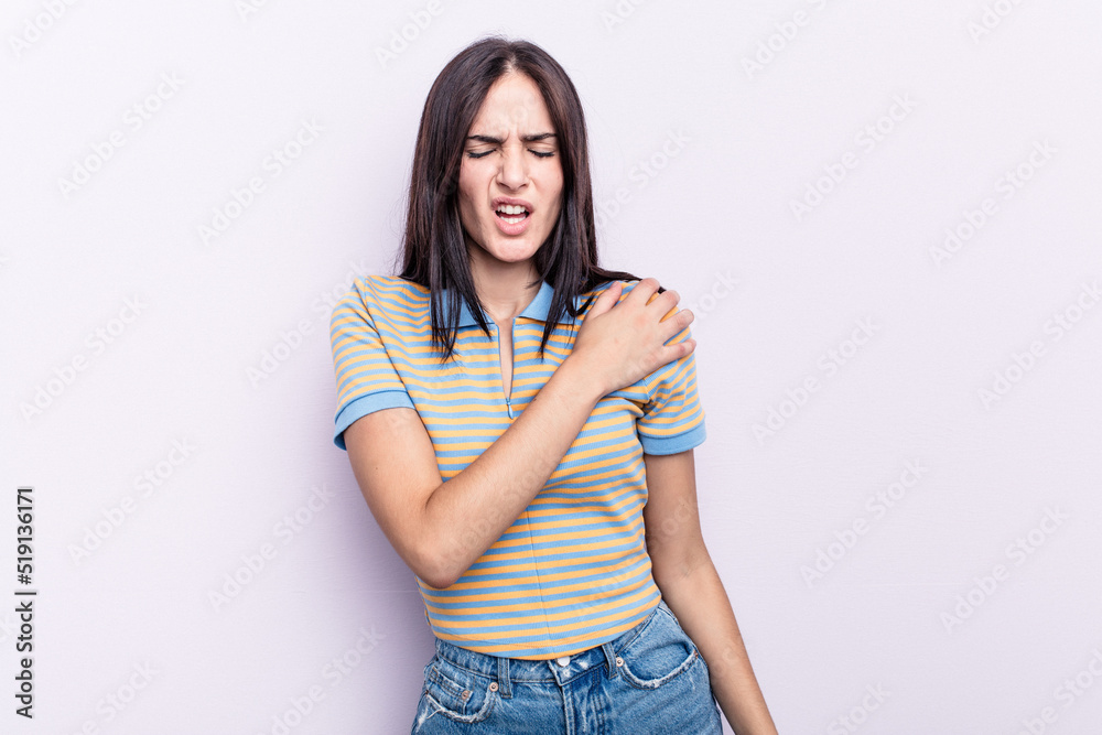 Young caucasian woman isolated on pink background having a shoulder pain. Young caucasian woman isolated on pink background having a shoulder pain.