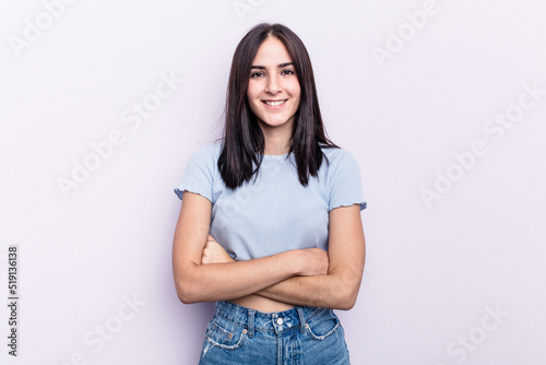 Young caucasian woman isolated on pink background who feels confident, crossing arms with determination. © Asier
