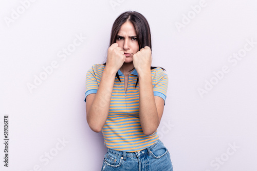 Young caucasian woman isolated on pink background throwing a punch, anger, fighting due to an argument, boxing.