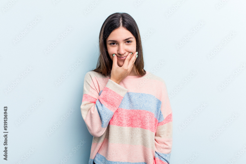 Young caucasian woman isolated on blue background doubting between two options.
