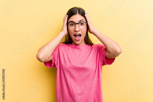 Young caucasian woman isolated on yellow background screaming, very excited, passionate, satisfied with something. © Asier