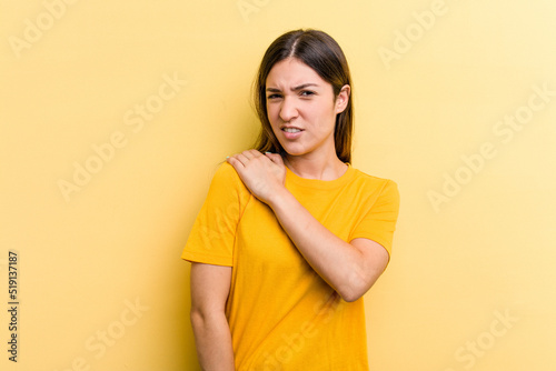 Young caucasian woman isolated on yellow background having a shoulder pain.