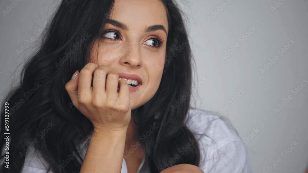 flirty young and brunette woman smiling while looking away at home. flirty young and brunette woman smiling while looking away at home.