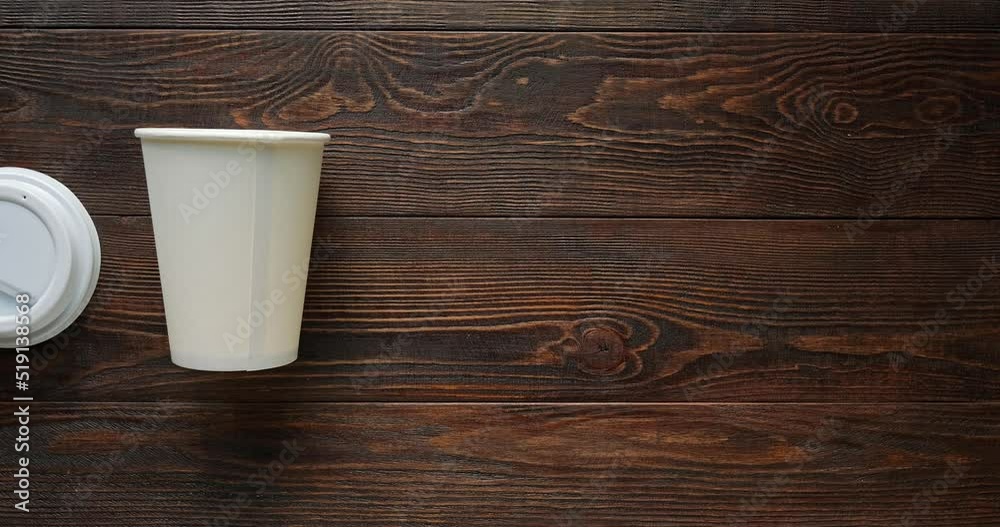 Glass of coffee to go on a wooden brown background. 4K stop motion animation