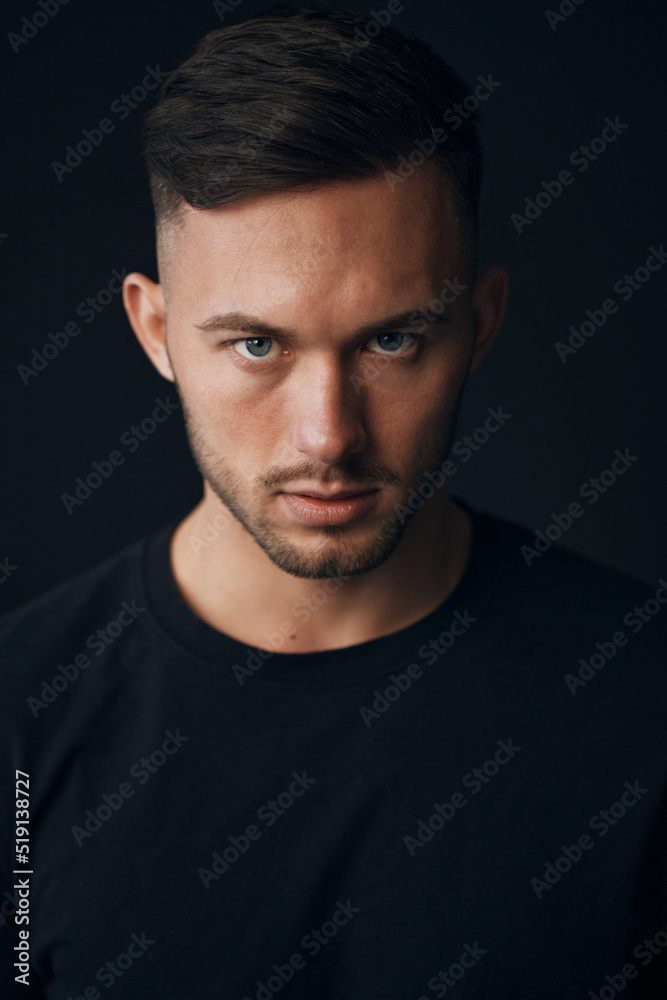 Modelling snapshots. Evil self-confident tanned attractive handsome man in classic suit jacket looks at camera posing isolated in black studio background. Fashion offer. Copy space for ad. Closeup