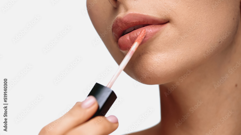 cropped view of young woman applying lip gloss isolated on white. cropped view of young woman applying lip gloss isolated on white.