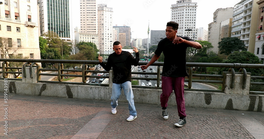 Obraz premium Happy hispanic and black African man dancing in city