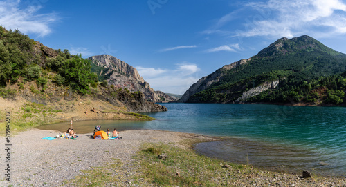 bathers on the beach of Ermita de Santa Justa or San Clemente, Escales reservoir, Noguera Ribagorzana, Huesca, Spain photo