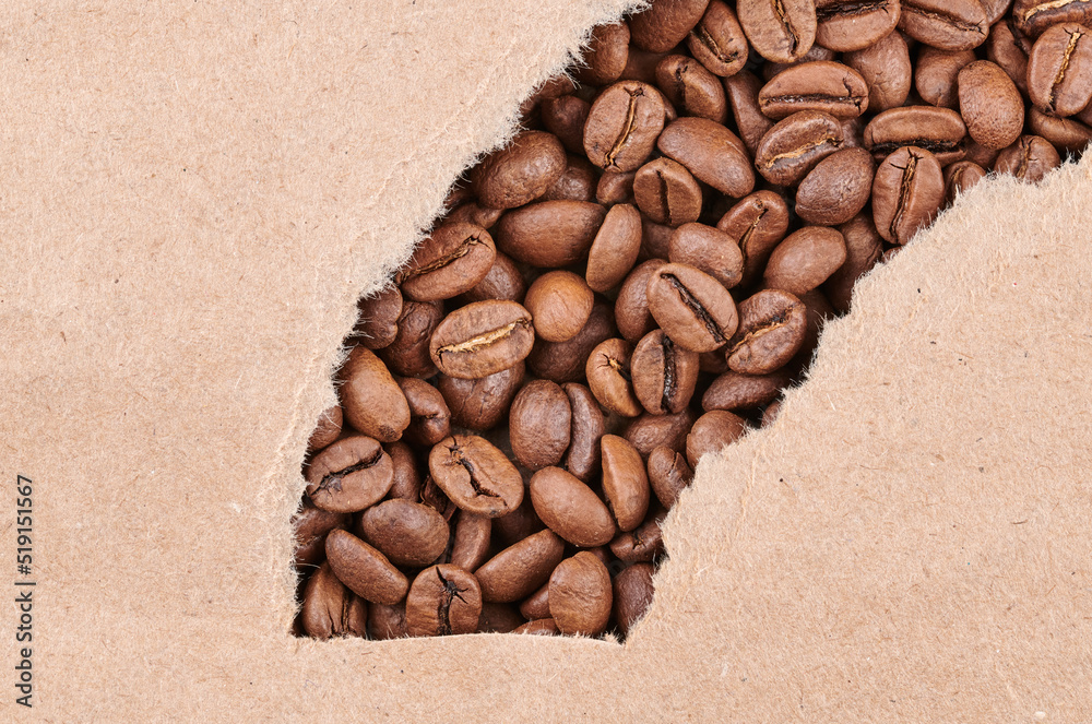 Roasted coffee beans decorated with kraft paper close-up creative background Roasted coffee beans decorated with kraft paper close-up creative background