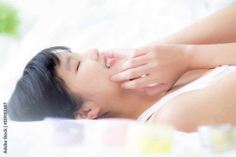 Obraz premium Beautiful of young asian woman smiling and lying on bed at bedroom, beauty of girl touch cheek with hygiene and healthy, cream and lotion, cosmetic and makeup, skin care and lifestyles concepts.