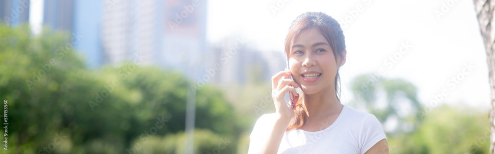Happiness young asian woman standing and talking on smart phone in the park, girl relaxation and receiving smartphone and speaking on summer in the garden, lifestyles and communication concept. Happiness young asian woman standing and talking on smart phone in the park, girl relaxation and receiving smartphone and speaking on summer in the garden, lifestyles and communication concept.