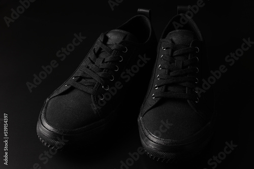 Black sneakers on black background