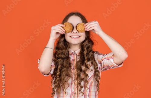Fotografie, Obraz glad teen girl with oatmeal cookies on orange background