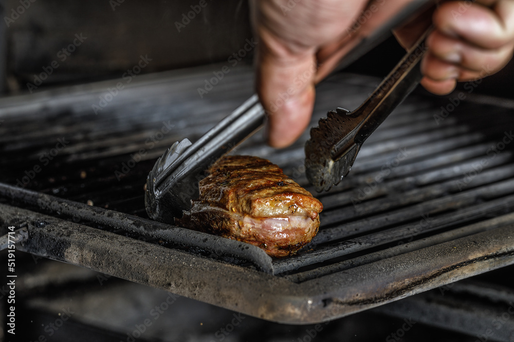 An organic  marinated duck fillet being grilled