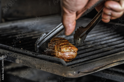 An organic marinated duck fillet being grilled