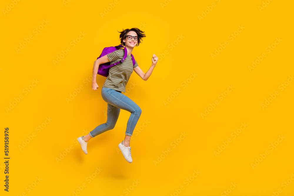 Full length photo of funny pretty girl dressed green t-shirt eyewear rucksack walking empty space isolated yellow color background