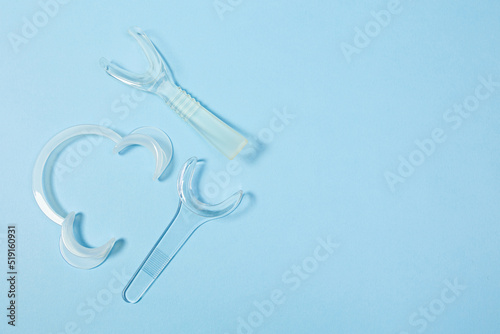 set of several Retractor Dental lip retractor Access to the oral cavity. Wide mouth opening for a dental procedure on a clean blue background photo