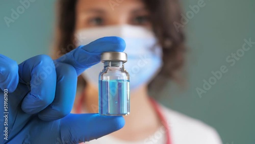 Woman Doctor holds an ampule with medicine in her hand. vaccine for disease in doctor hand. covid 19. the doctor prescribed an injection treatment. doctor is ready to give an injection to patient photo
