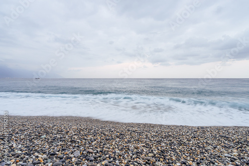 Beautiful scenic of ocean with sprawling stone covered beach. photo