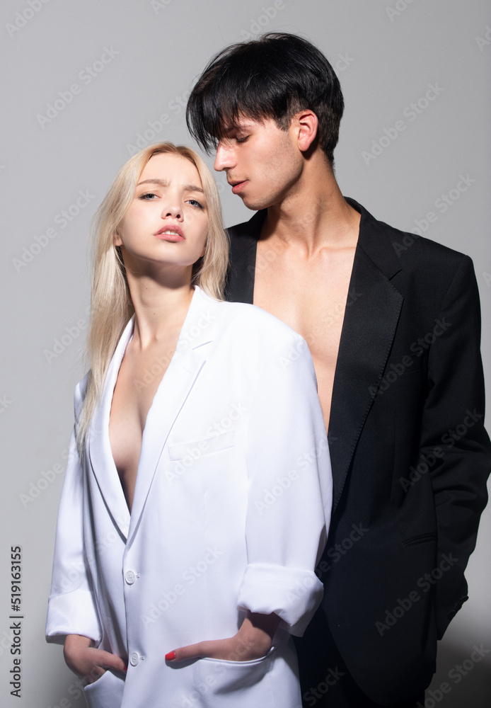 Sexy young couple in love. Young man and blonde woman. Fashion young couple on gray background in studio. Fashionable people. Sexy young couple in love. Young man and blonde woman. Fashion young couple on gray background in studio. Fashionable people.