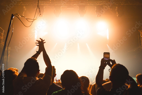 The audience applauded by the stage artist. They shines the spotlight.
