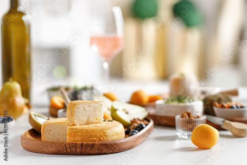 French and italian cheeses. Cheese and wine concept. Reblochon, Camembert, Caciotta, Langres on wooden plates with fruits and honey. Cheese plate, dish. photo