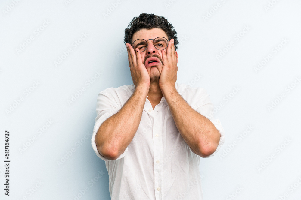 Young caucasian man isolated on blue background whining and crying disconsolately.