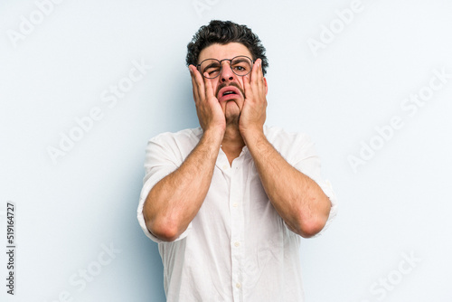 Young caucasian man isolated on blue background whining and crying disconsolately.