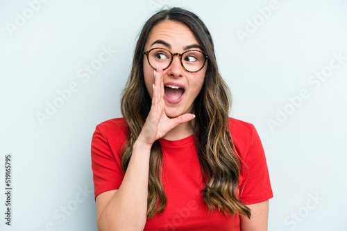 Young caucasian woman isolated on blue background shouting excited to front.