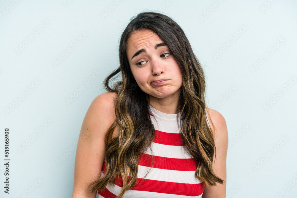 Young caucasian woman isolated on blue background shrugs shoulders and open eyes confused. Young caucasian woman isolated on blue background shrugs shoulders and open eyes confused.