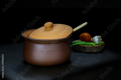 Still life of terracotta bowl with vegetables.