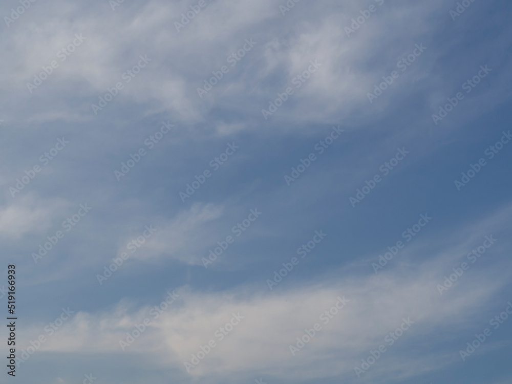 The natural background of the sky. Light whitish clouds in a gray-blue sky