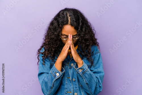 Foto Young hispanic woman isolated on purple background praying, showing devotion, religious person looking for divine inspiration