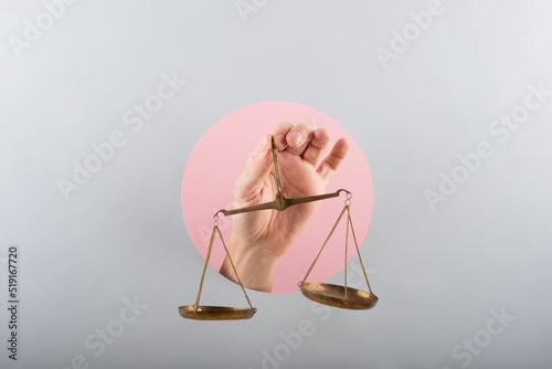 Fotótapéta man hand holding a balance on pink and blue background
