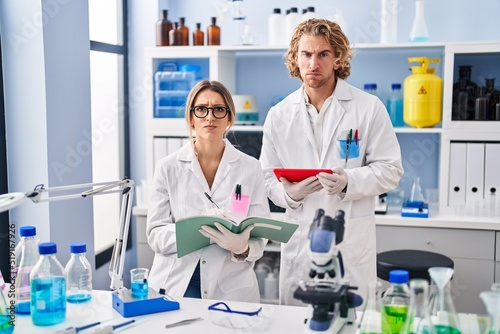 Two people working at scientist laboratory skeptic and nervous  frowning upset because of problem. negative person.