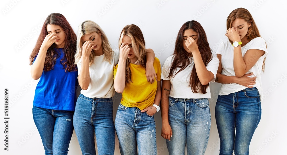 Group of young girl friends standing together over isolated background tired rubbing nose and eyes feeling fatigue and headache. stress and frustration concept. Group of young girl friends standing together over isolated background tired rubbing nose and eyes feeling fatigue and headache. stress and frustration concept.