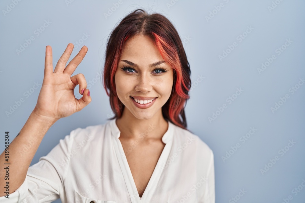 Young caucasian woman wearing casual white shirt over isolated background smiling positive doing ok sign with hand and fingers. successful expression. Young caucasian woman wearing casual white shirt over isolated background smiling positive doing ok sign with hand and fingers. successful expression.