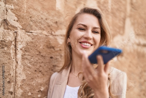 Young blonde woman smiling confident talking on the smartphone at park © Krakenimages.com