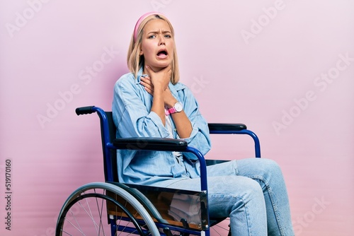 Beautiful blonde woman sitting on wheelchair shouting suffocate because painful strangle. health problem. asphyxiate and suicide concept.