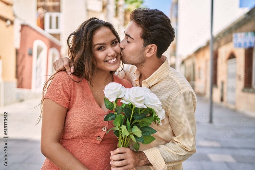 Man and woman couple holding bouquet of flowers hugging and kissing ...