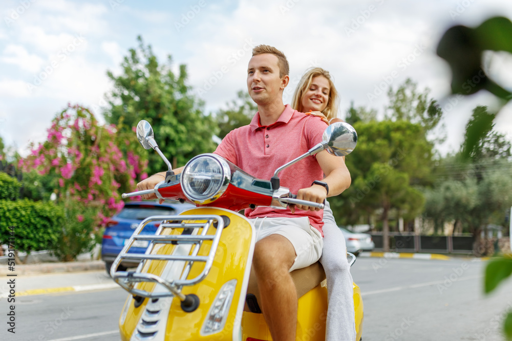 Obraz premium Happy couple in love riding a motorbike on summer city streets ,man and woman travel . Young riders enjoying themselves on trip. Adventure and vacations concept.
