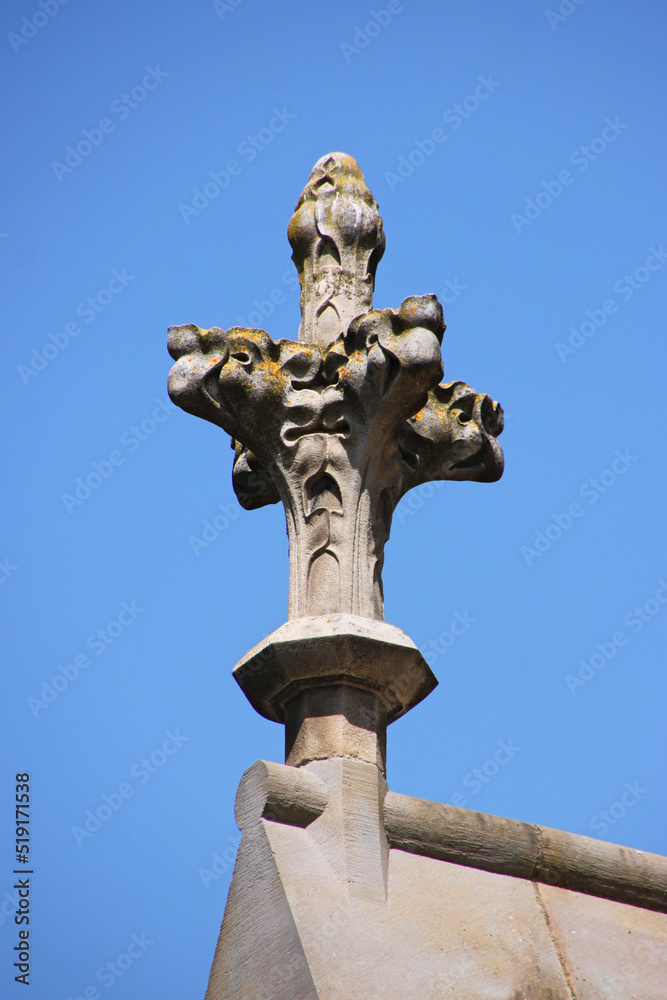 Restored gothic cross flower sculpture on the roof ridge of St Michel cathedral in the city of Carcassonne, Occitanie region in France