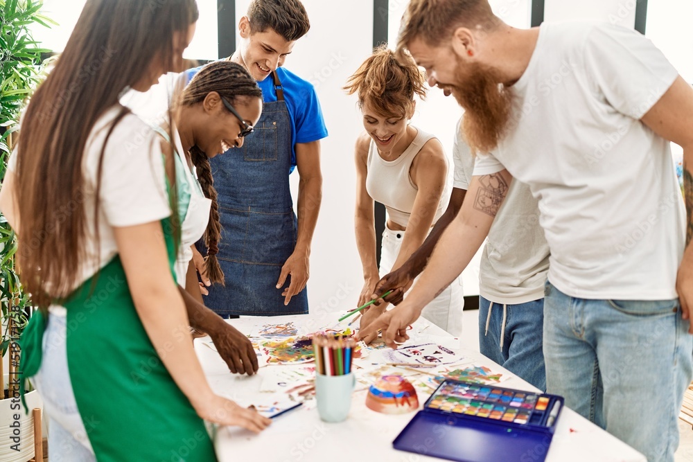 Group of people smiling happy drawing standing around the table at art studio. Group of people smiling happy drawing standing around the table at art studio.