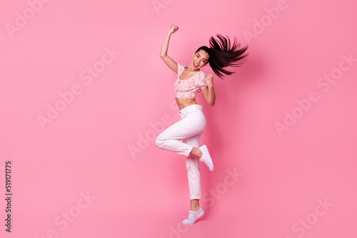 Full length portrait of cheerful delighted vietnamese girl raise fists triumph isolated on pink color background © deagreez
