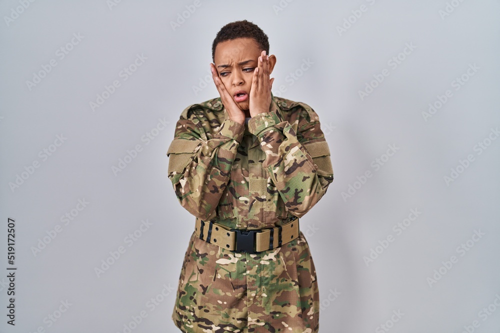 Beautiful african american woman wearing camouflage army uniform tired hands covering face, depression and sadness, upset and irritated for problem