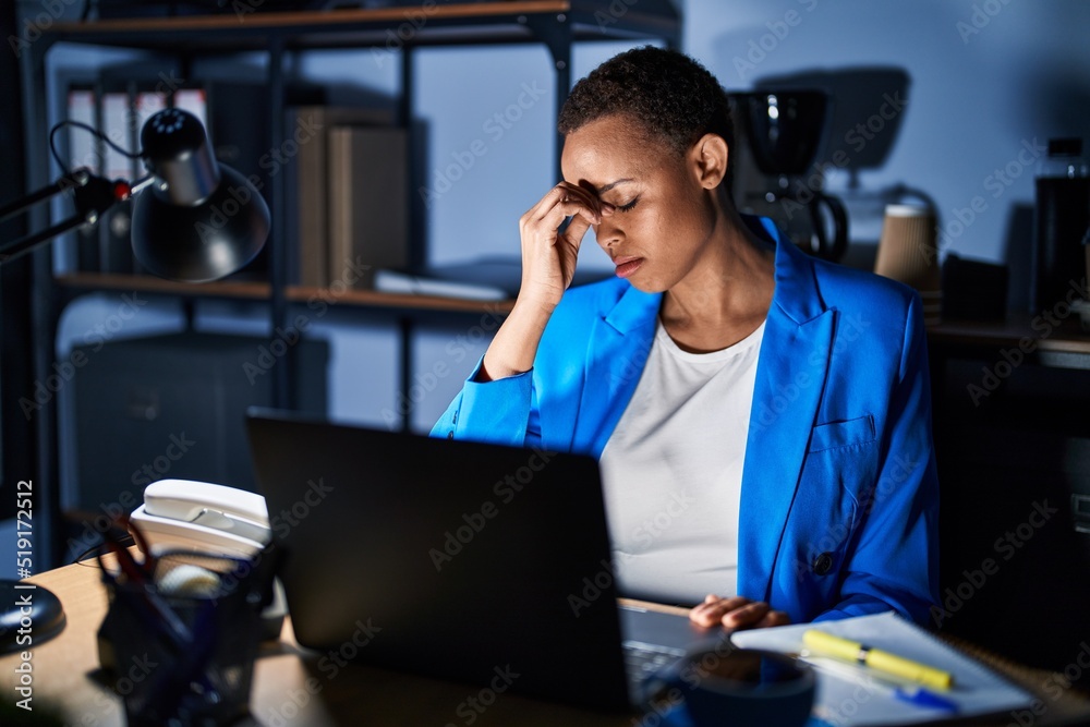 Beautiful african american woman working at the office at night tired rubbing nose and eyes feeling fatigue and headache. stress and frustration concept.