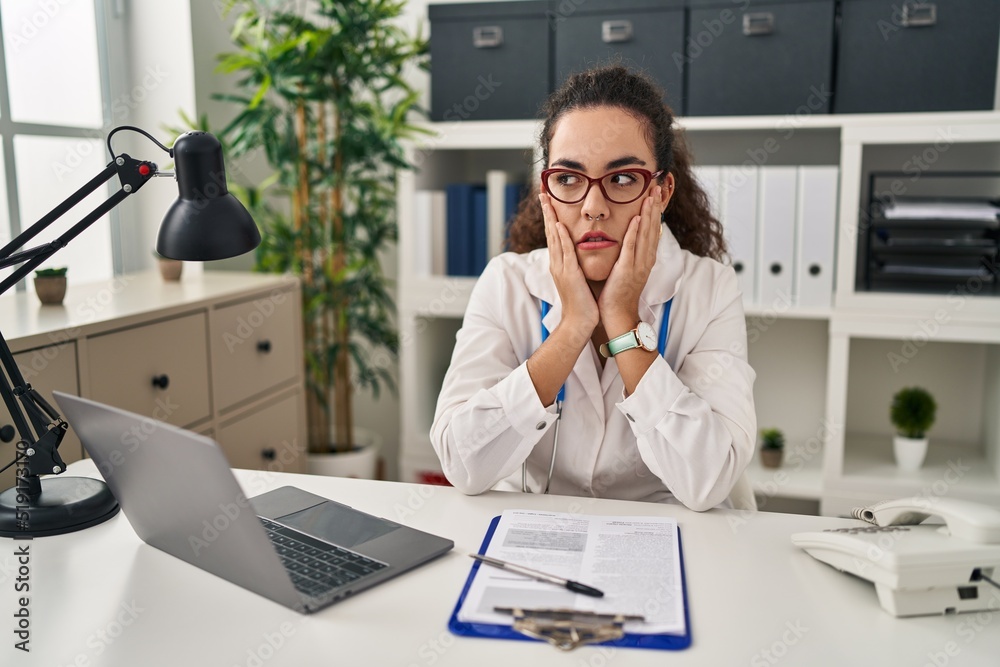 Young hispanic woman wearing doctor uniform and stethoscope tired hands covering face, depression and sadness, upset and irritated for problem Young hispanic woman wearing doctor uniform and stethoscope tired hands covering face, depression and sadness, upset and irritated for problem