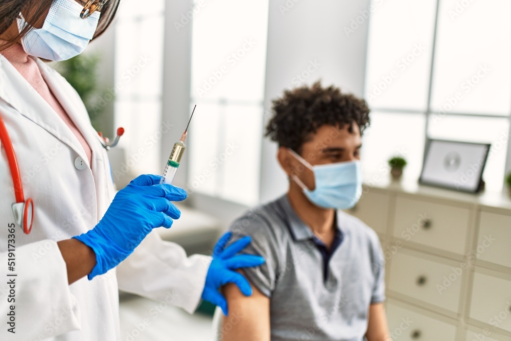 Naklejka premium Young doctor woman injecting covid-19 coronavirus vaccine for man.